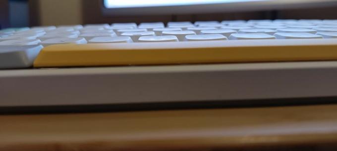 Valge NuPhy Air75 V2 klaviatuur puidust töölaual